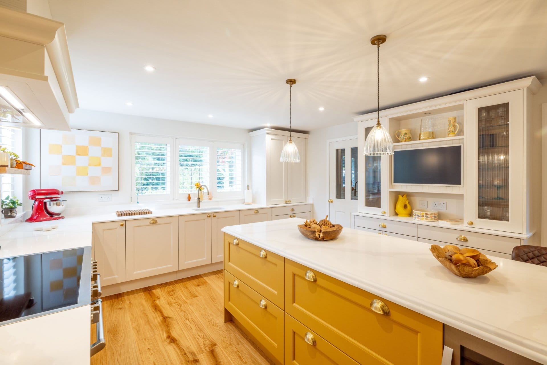 Artizan Interiors traditional shaker kitchen featuring a statement yellow island, quartz worktops, bespoke cabinetry and warm oak flooring.