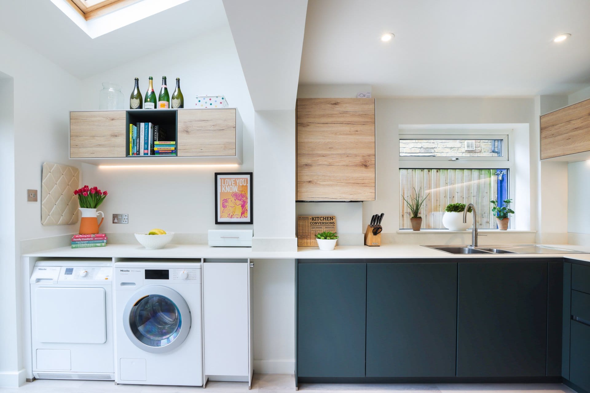 20230329133040_0E8A2887 Artizan Interiors luxury shaker kitchen featuring a large marble waterfall island, upholstered breakfast bar seating, bespoke cabinetry and soft contemporary lighting.