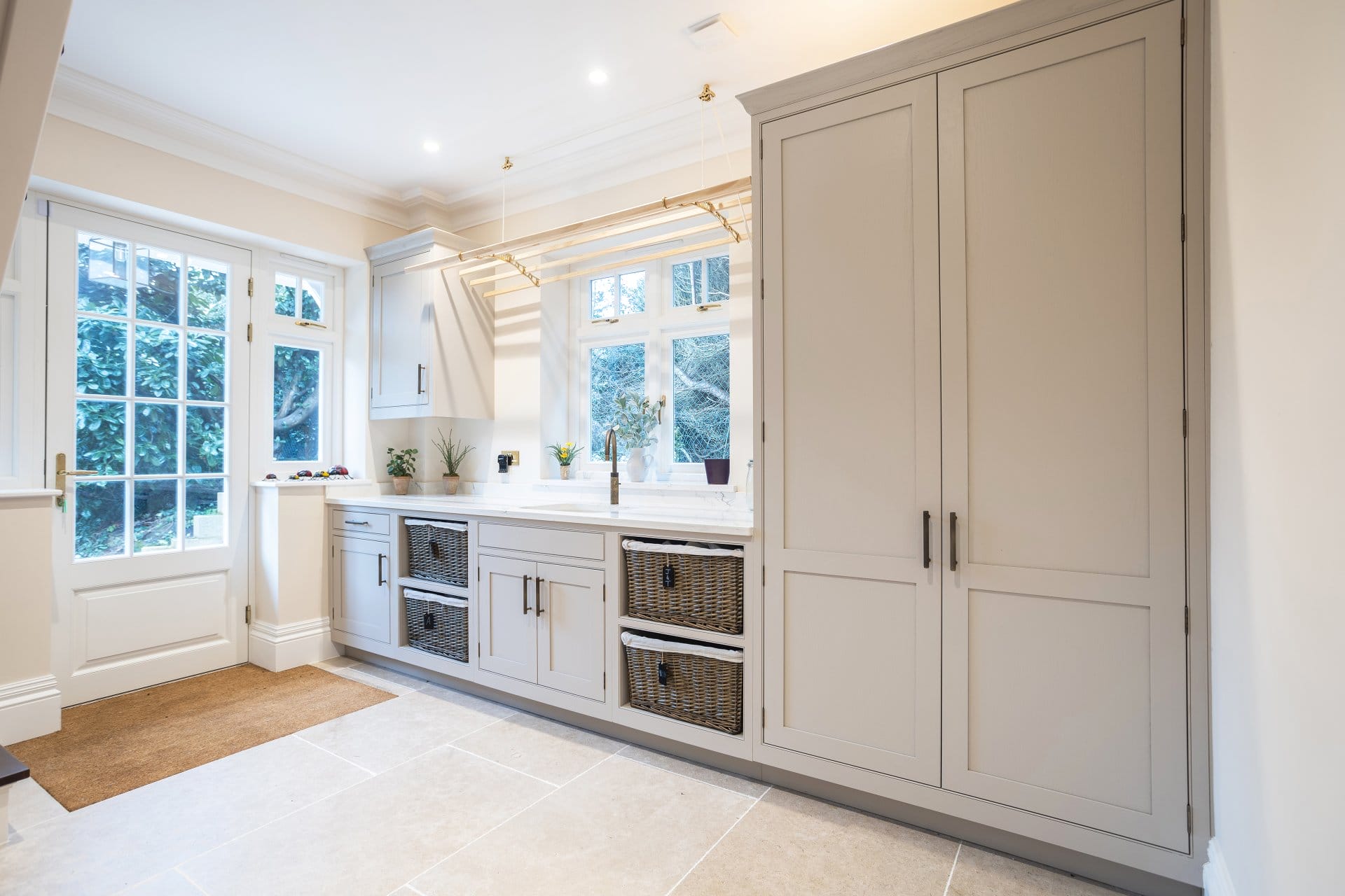 23 Cleves Way_Feb 24_4438_LR Artizan Interiors contemporary navy shaker kitchen featuring a large island, marble-effect worktops, herringbone flooring and elegant pendant lighting.