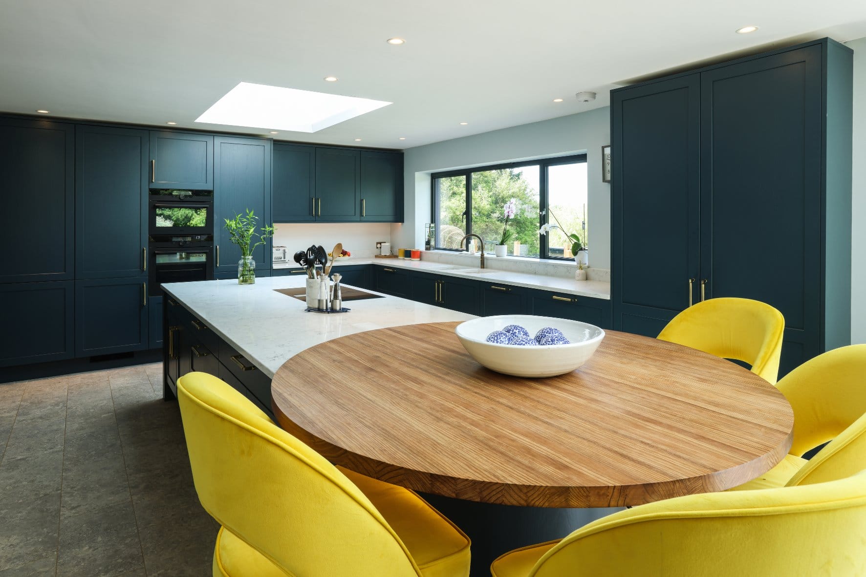 Untitled design (11) Artizan Interiors modern dark handleless kitchen featuring matte black cabinetry, a white island breakfast bar, integrated appliances and contemporary pendant lighting.